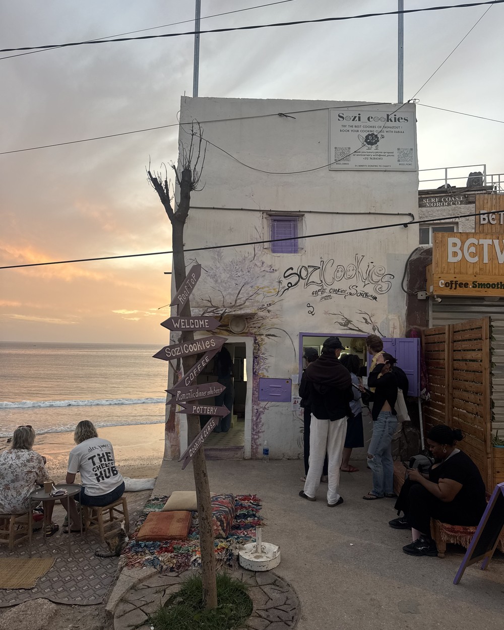 People queuing outside the Soz Cookies shopfront above the beach at Taghazout at sunset, Morocco