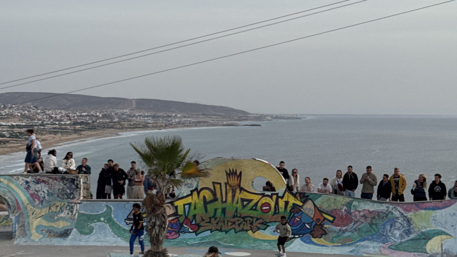 Painted skate park above the bay at Taghazout with the town on the hillside behind, Morocco