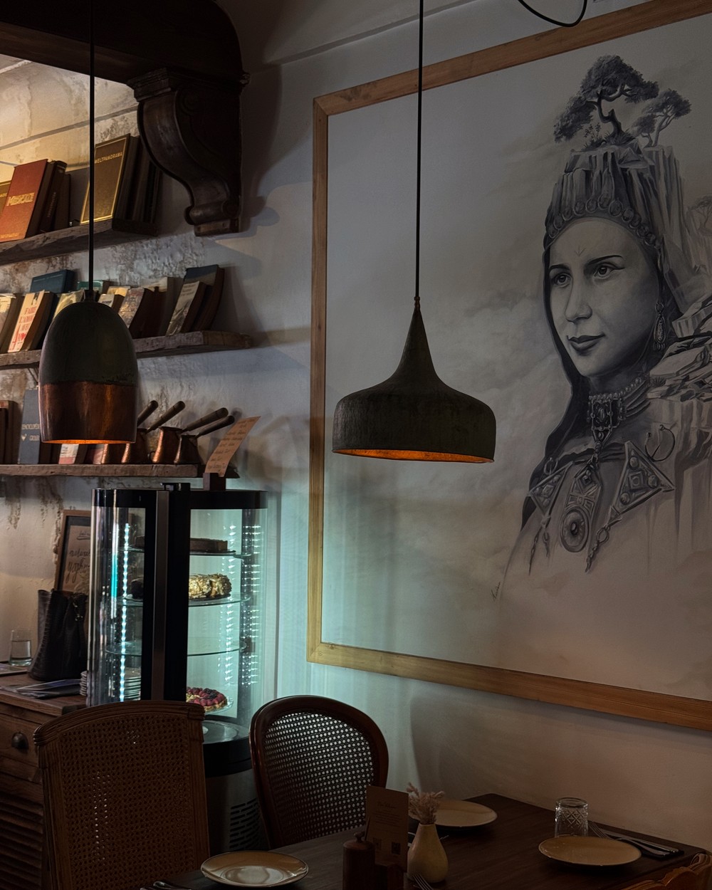 Modern cafe interior with pendant lighting and a large portrait artwork in Marrakech, Morocco