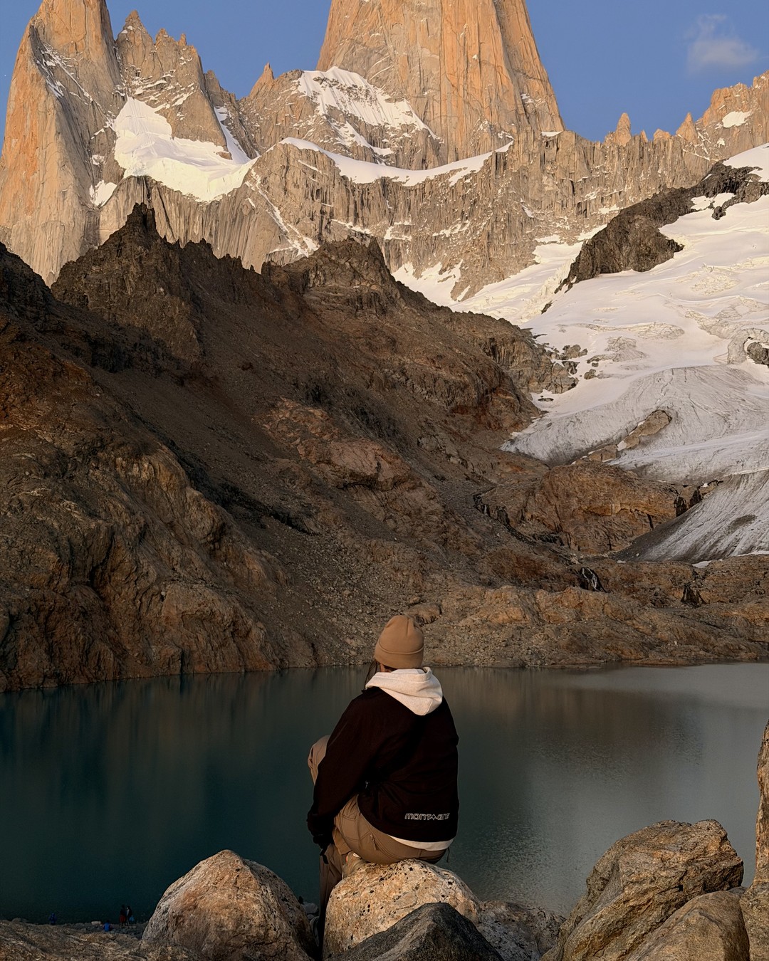 Ellen sitting on a rock at Laguna de los Tres before sunrise