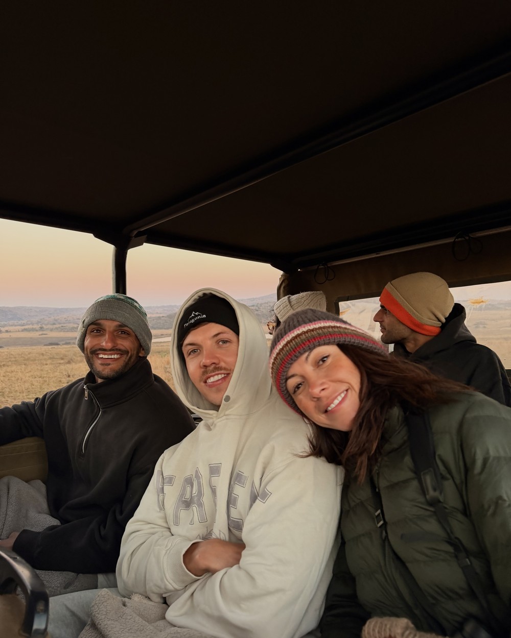 Group of people wrapped up in the back of an open safari vehicle
