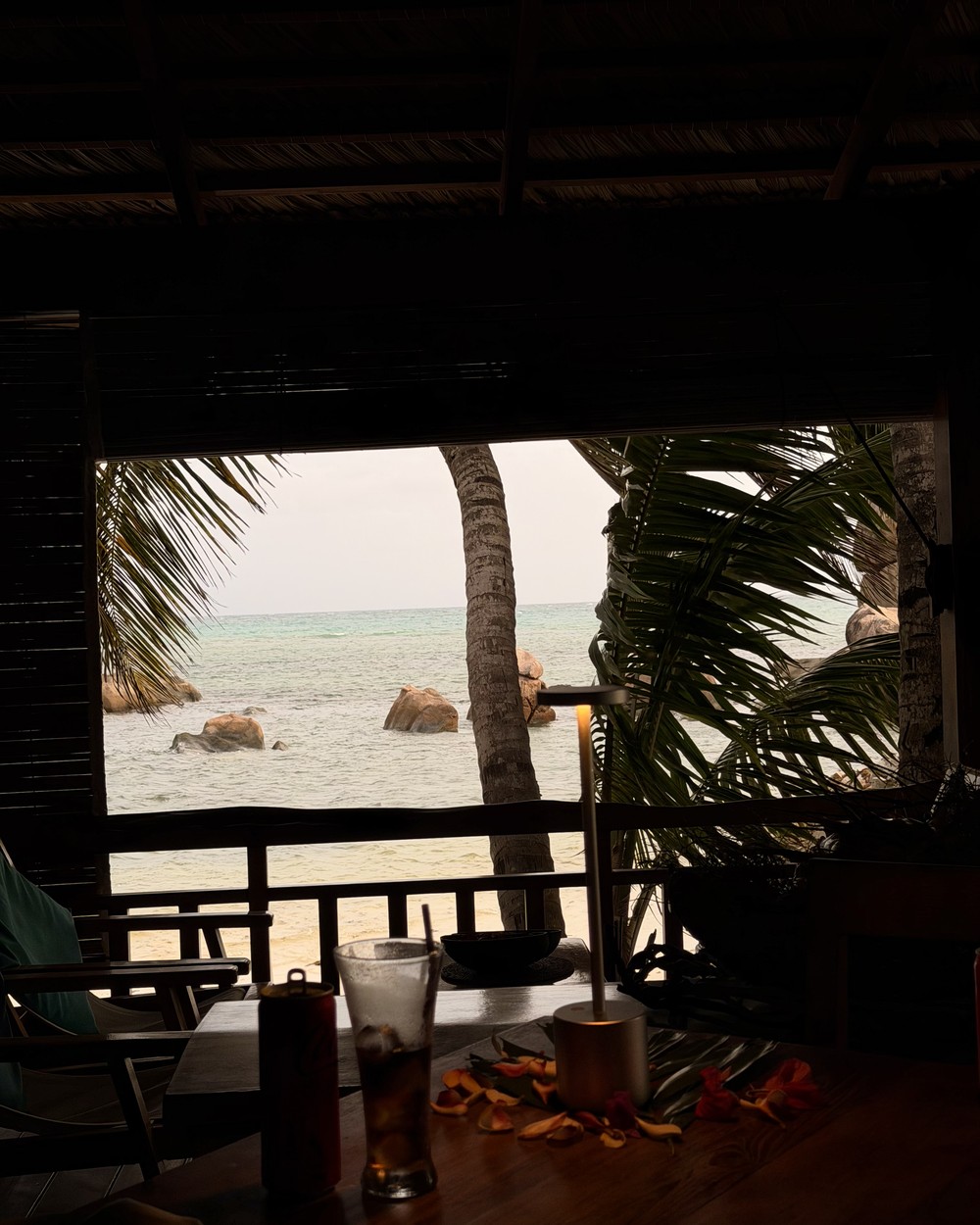 View out from inside the dining room at Les Rochers on Praslin towards the beach and granite boulders