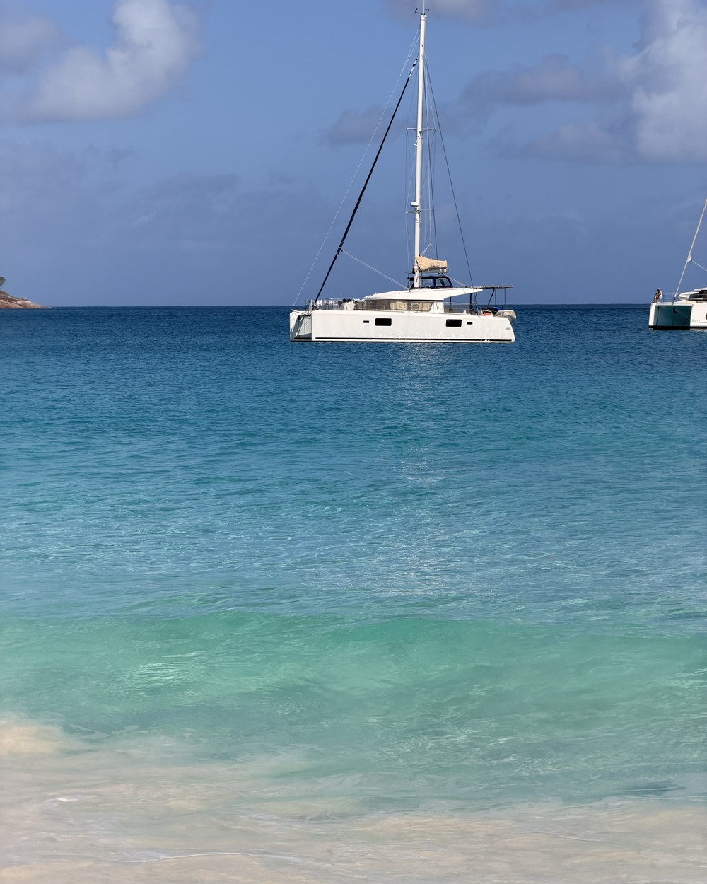A catamaran in turquoise water off Praslin in the Seychelles
