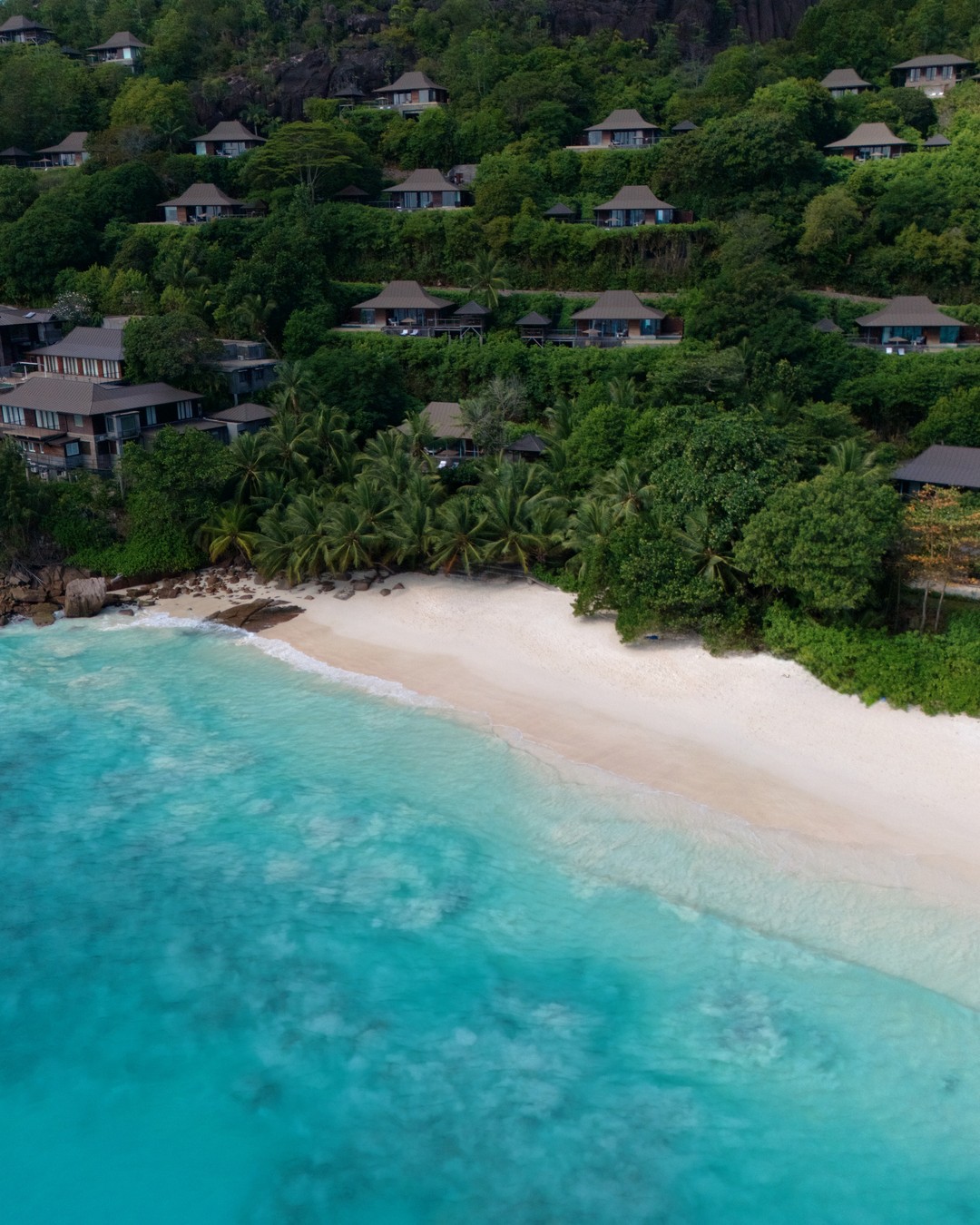 Aerial view of hillside villas above Petite Anse beach on Mahe in Seychelles