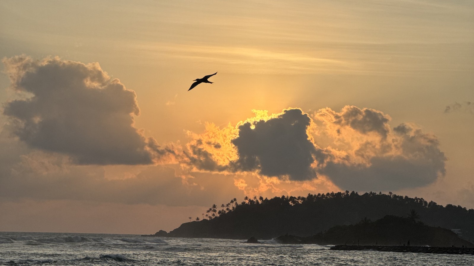 Fishermen in outrigger canoes on calm water at sunset on the south coast of Sri Lanka