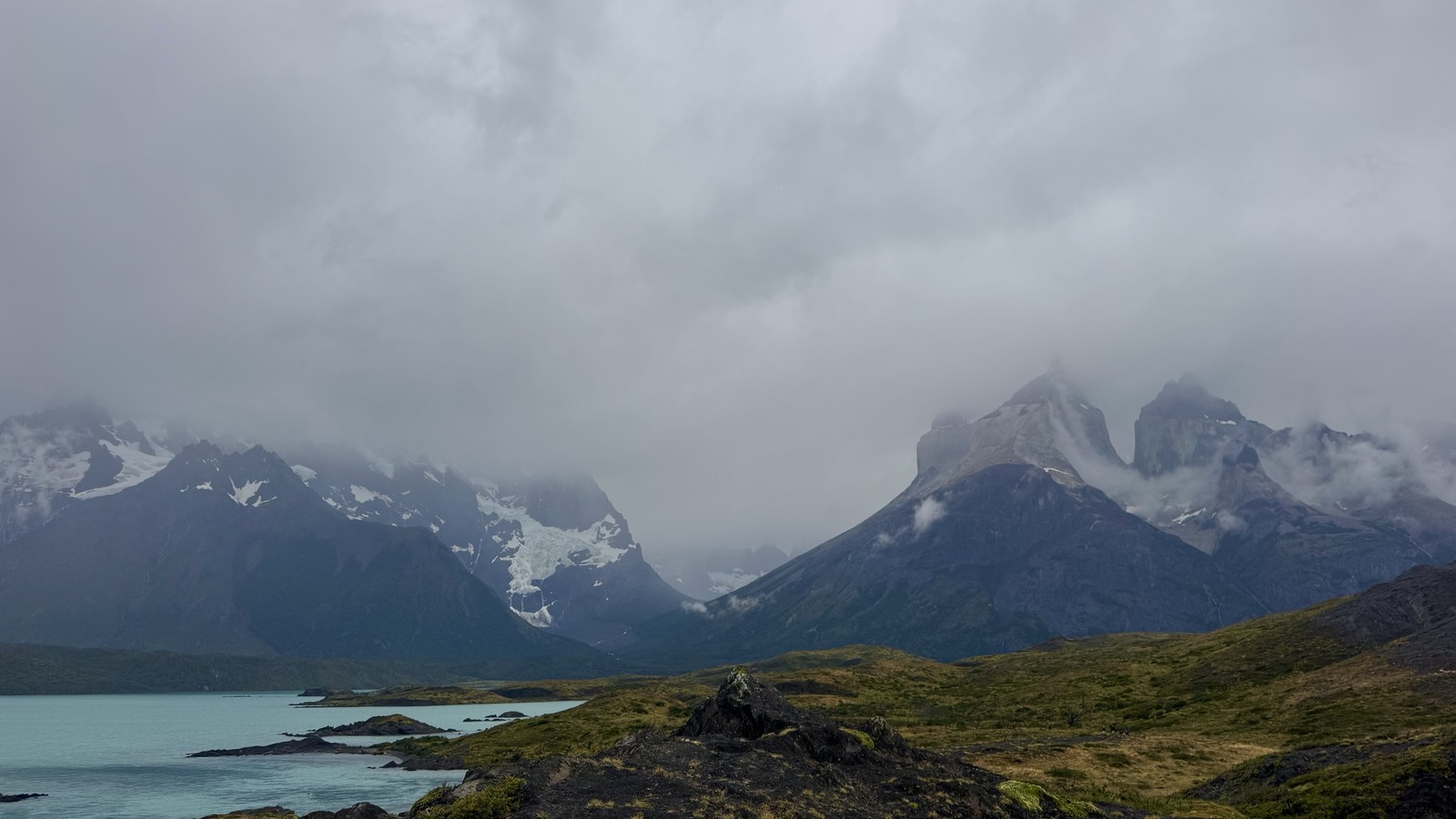 The Cuernos del Paine under heavy cloud above a turquoise lake in Torres del Paine