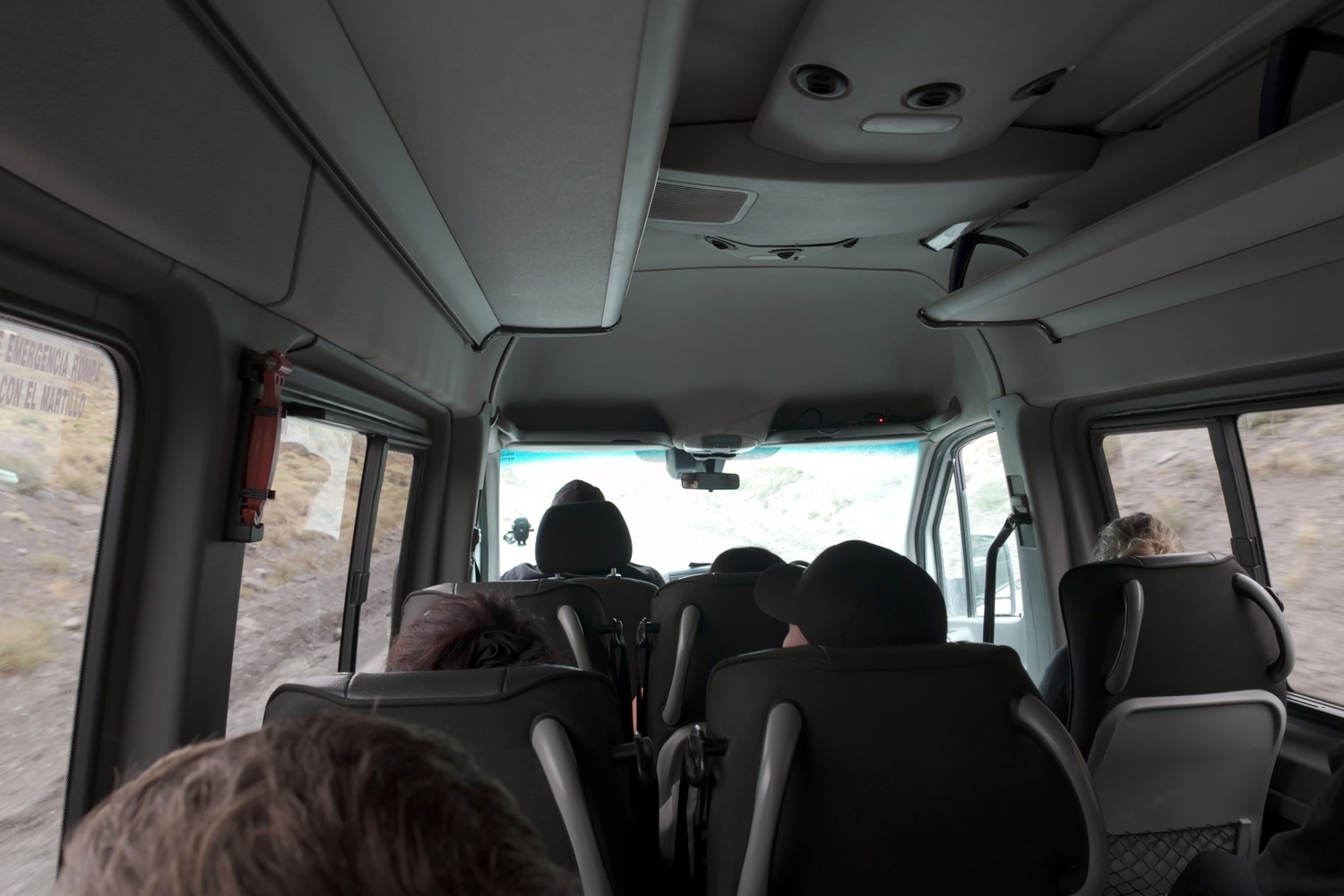 Inside the small tour van on a gravel road through Torres del Paine, other passengers seated ahead