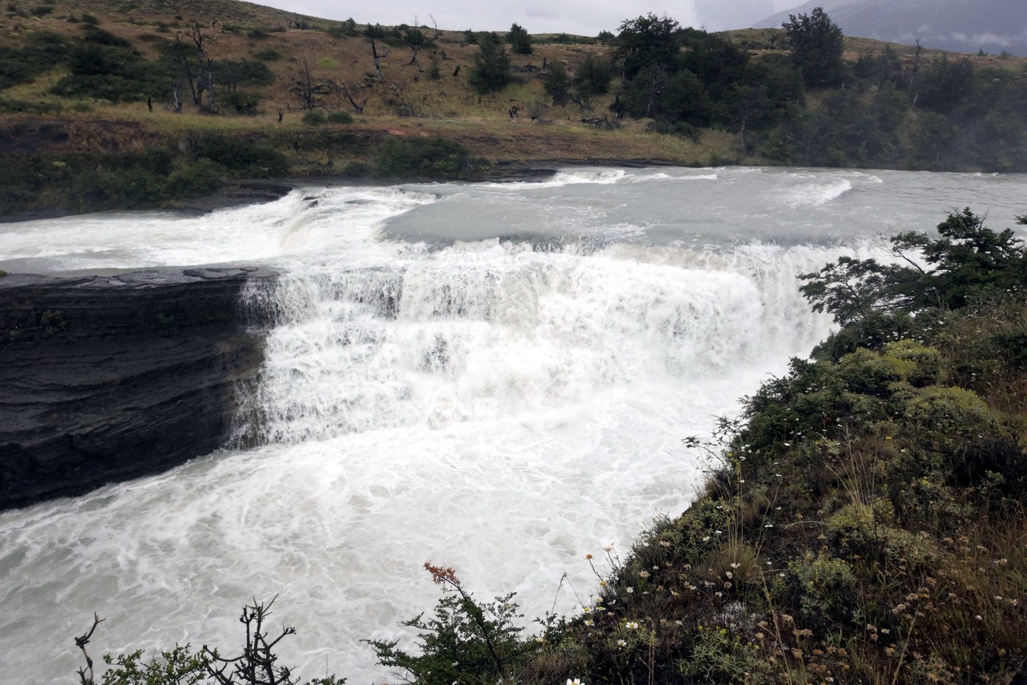 White water pouring over a wide rock ledge on the river in Torres del Paine National Park