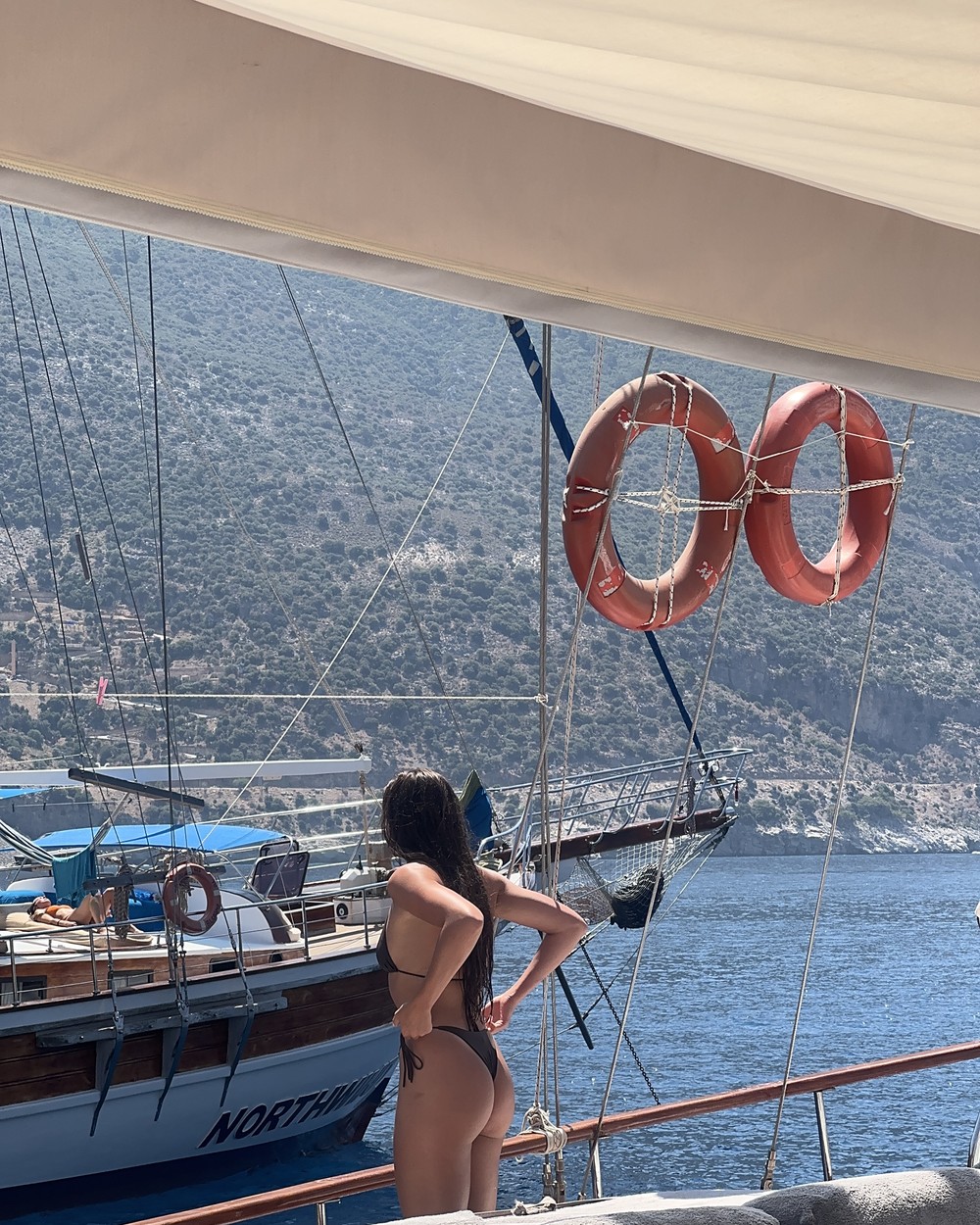 Woman standing on the deck of a traditional wooden gulet boat on the Turkish Riviera
