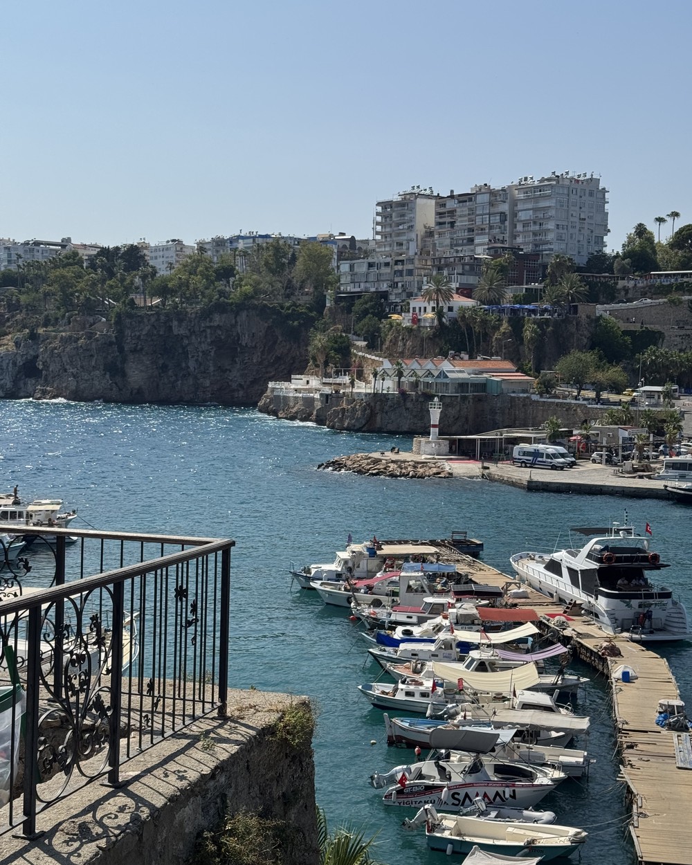 Fishing boats moored in the old harbour at Antalya below stone walls