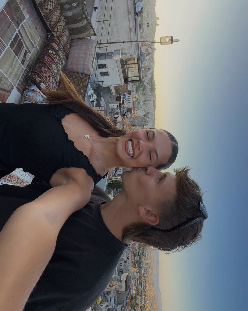 Couple on a terrace looking out over the rock formations and town of Cappadocia