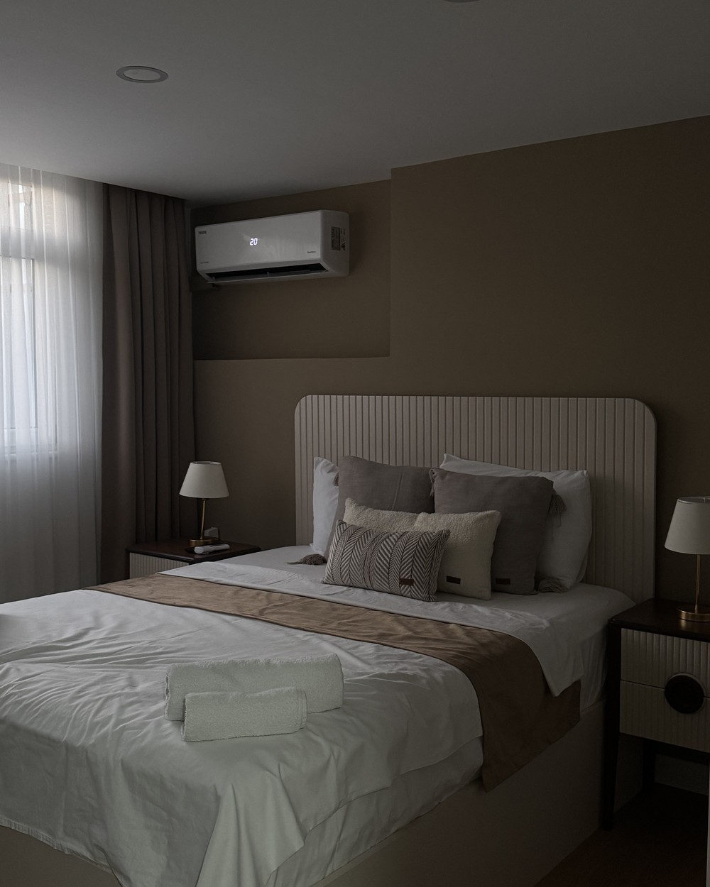 Neat hotel bedroom with a made bed, bedside lamps and air conditioning in Istanbul