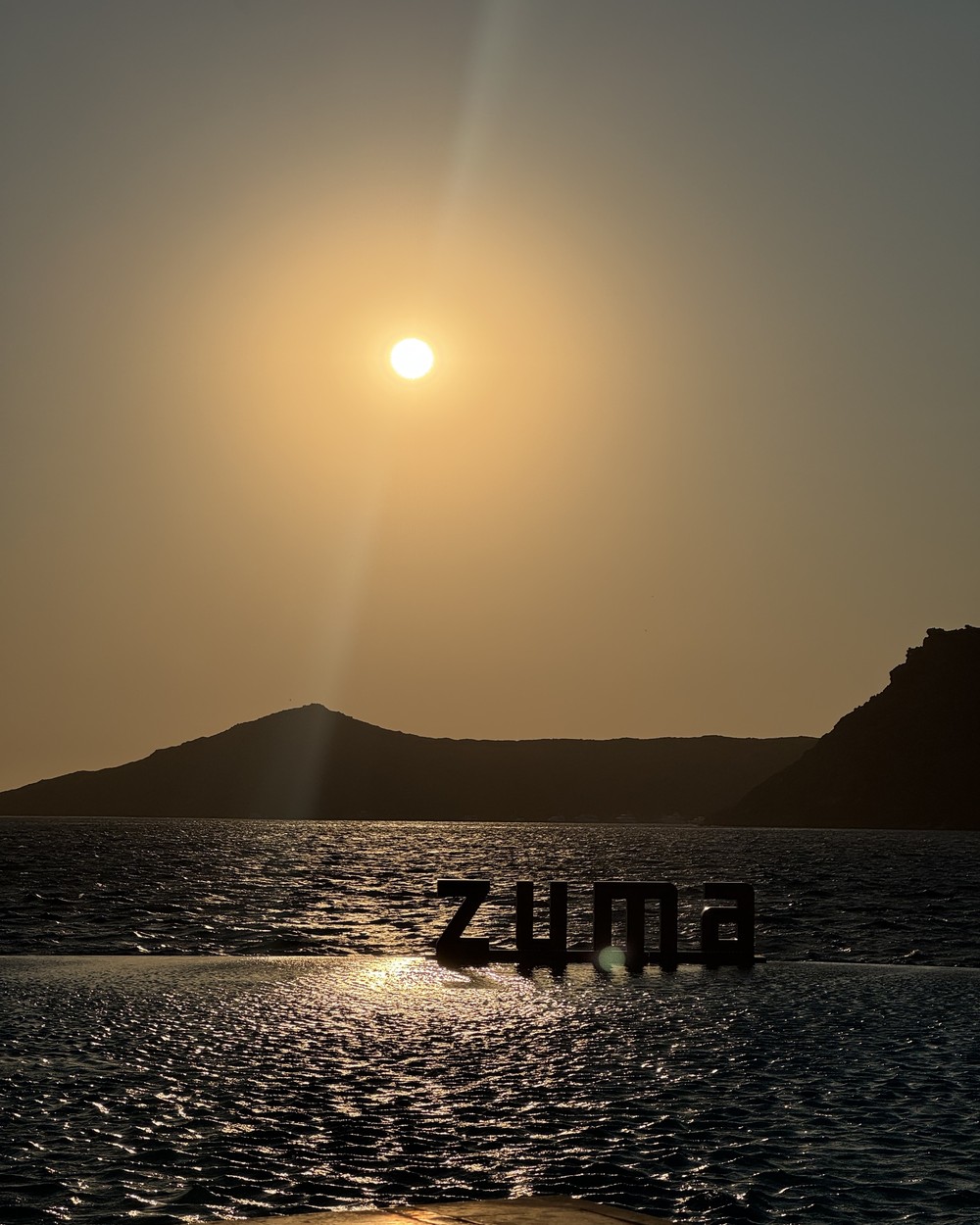 Table set for dinner at Zuma in Bodrum with the bay and headland behind at sunset