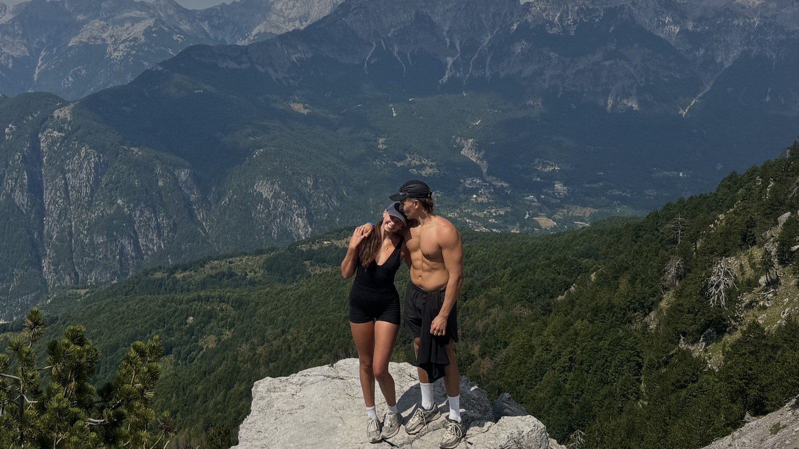 Ellen and Daniel on a rocky outcrop with the Albanian Alps behind them on the Valbonë to Theth trail