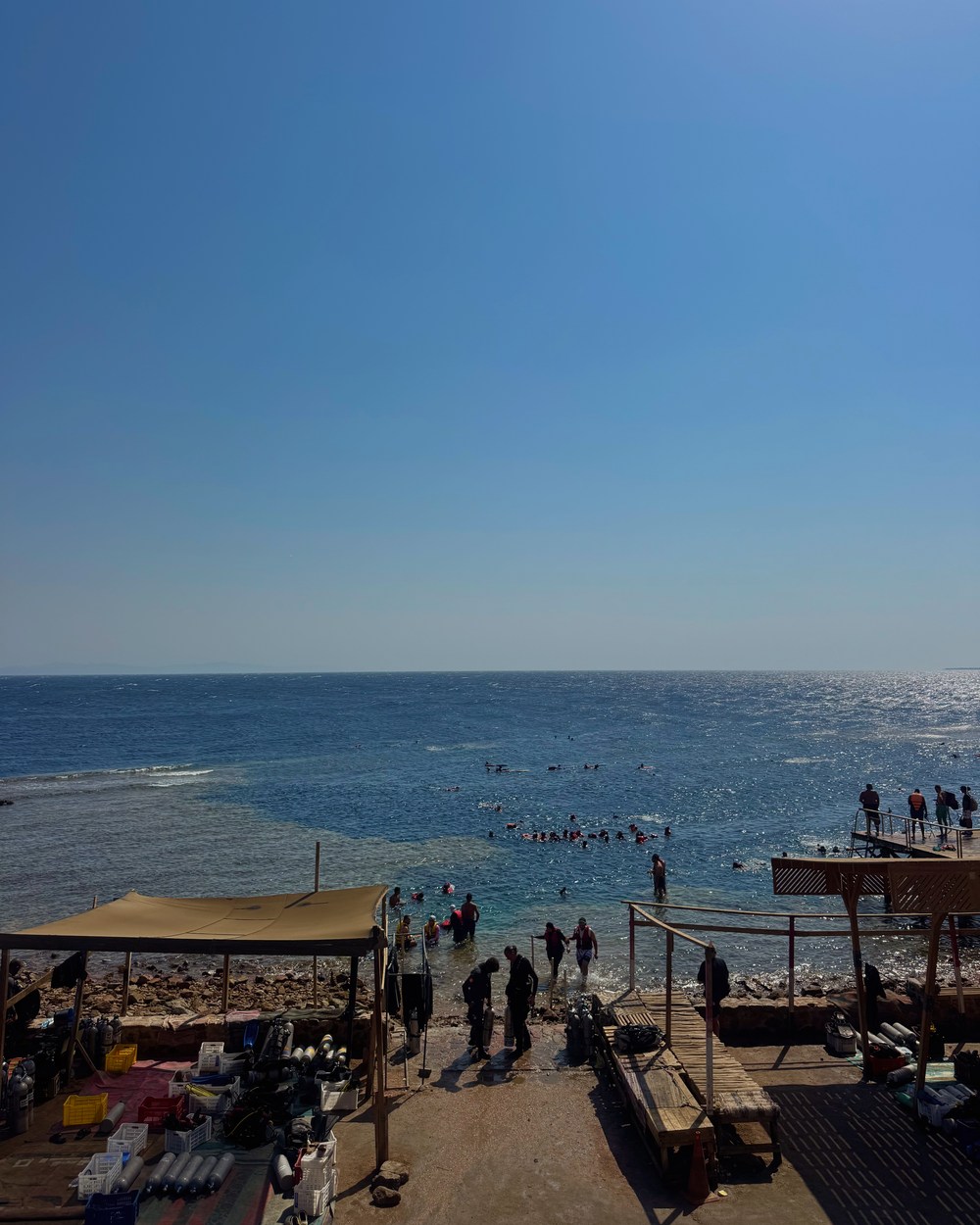 Snorkellers and divers entering the Blue Hole from the rocky Dahab shoreline
