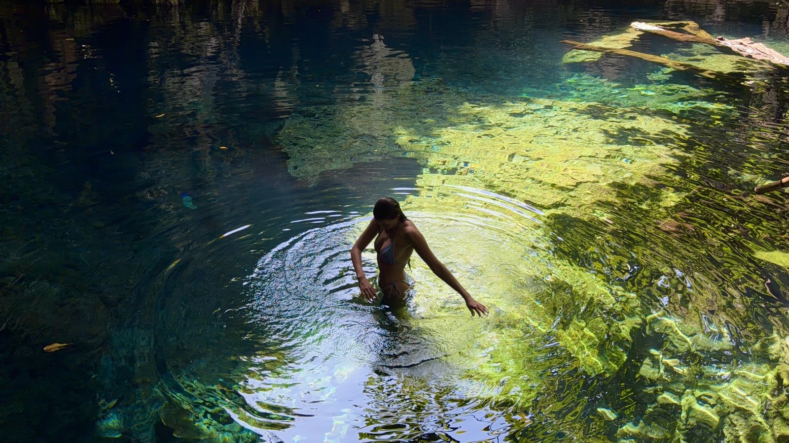 Ellen swimming in clear sunlit water at Maalum Cave in Paje, Zanzibar