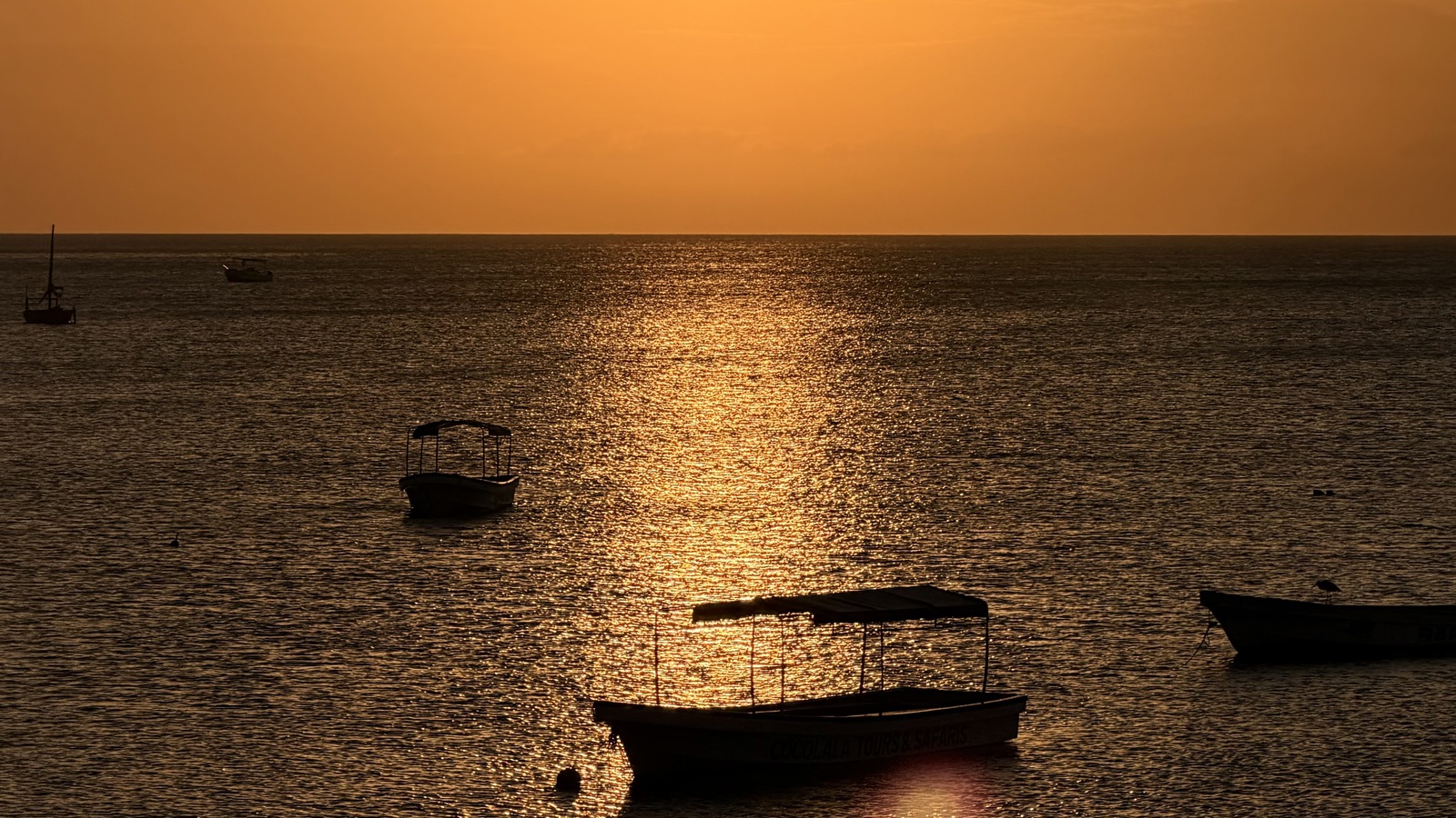 Golden sunset over the sea and boats off Nungwi, photographed from Maisha