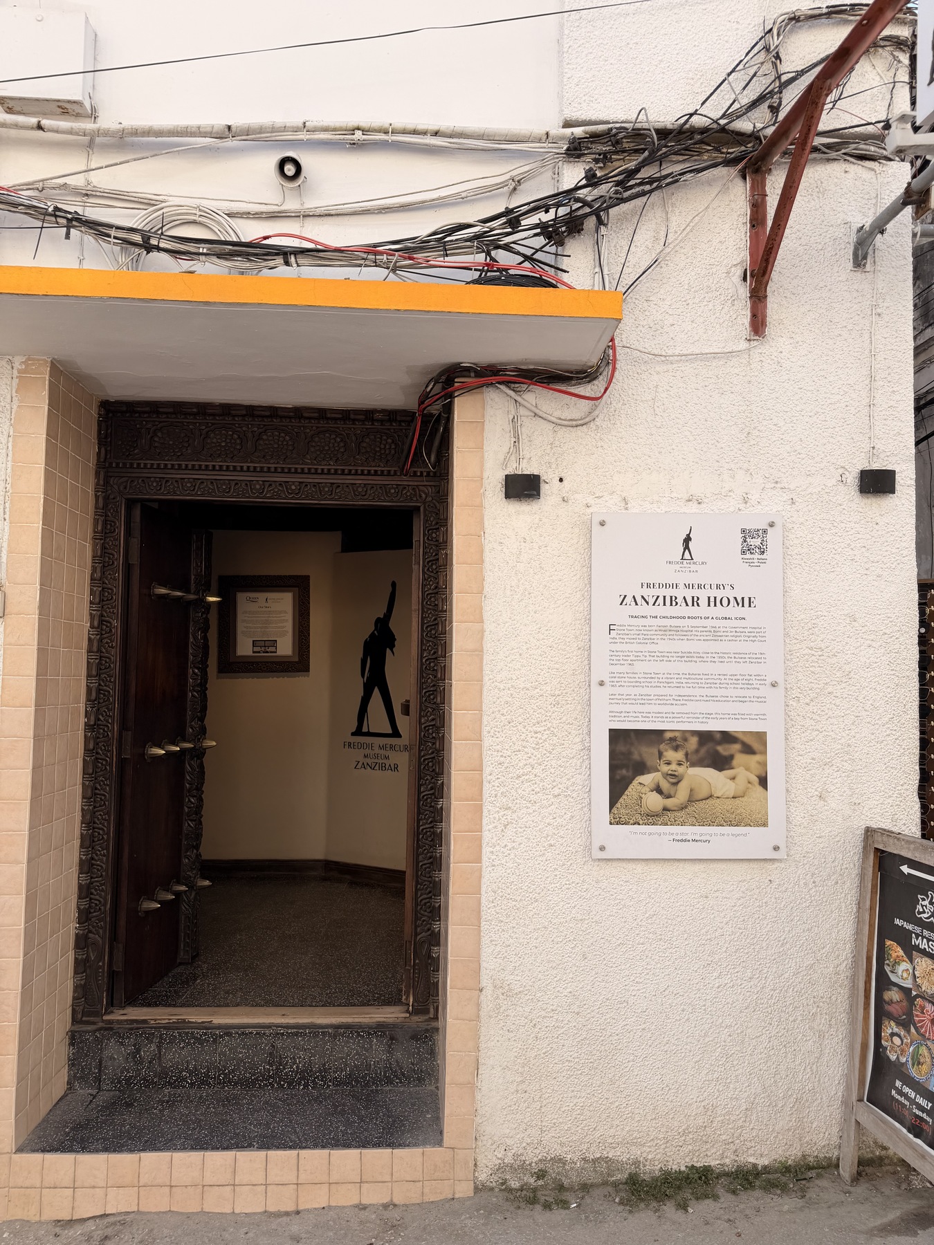Entrance and childhood-home information board at the Freddie Mercury Museum in Stone Town