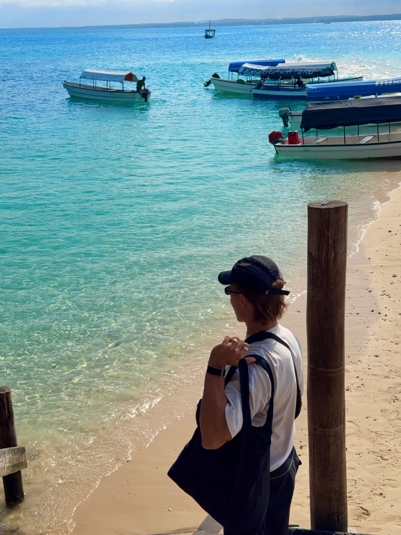 Daniel at the Prison Island landing steps beside boats in clear turquoise water