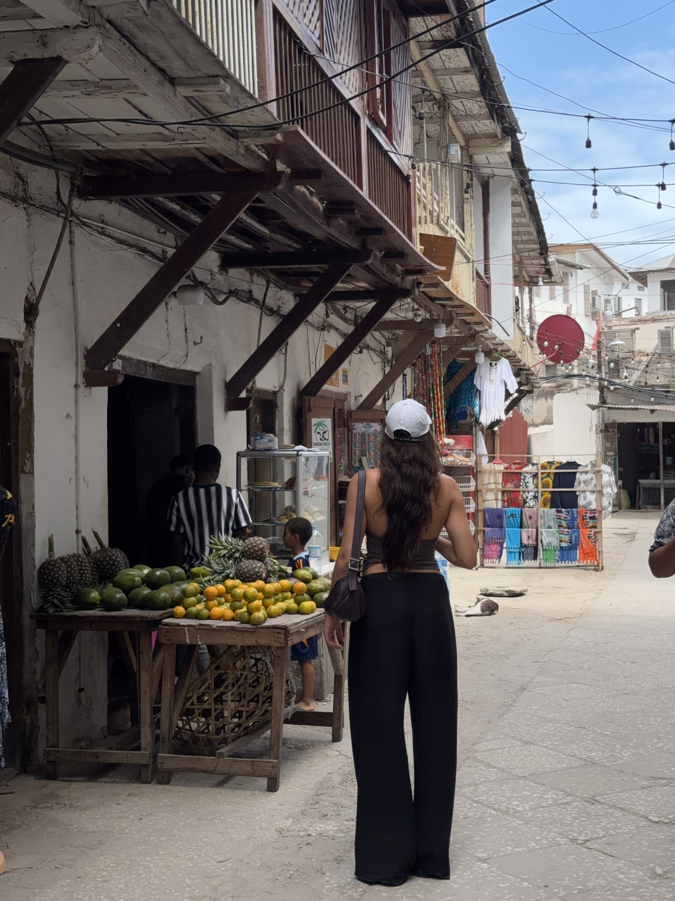 Ellen walking past fruit stalls in Stone Town, Zanzibar