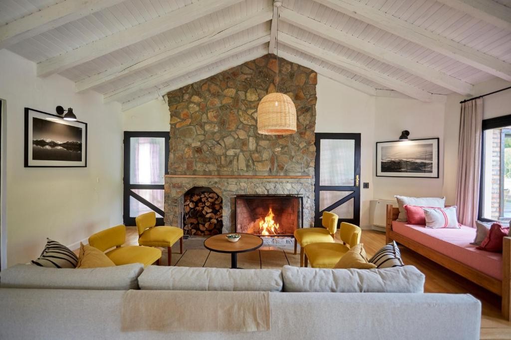 Lounge with a stone fireplace at Hostería El Puma in El Chaltén
