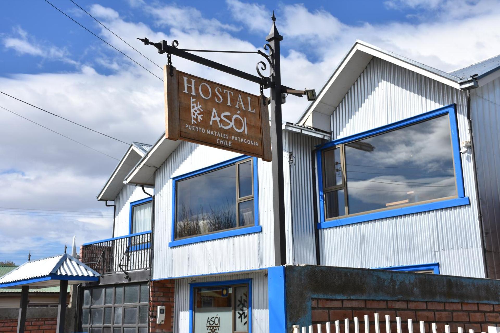 The blue and white front of Asói Hostal in Puerto Natales