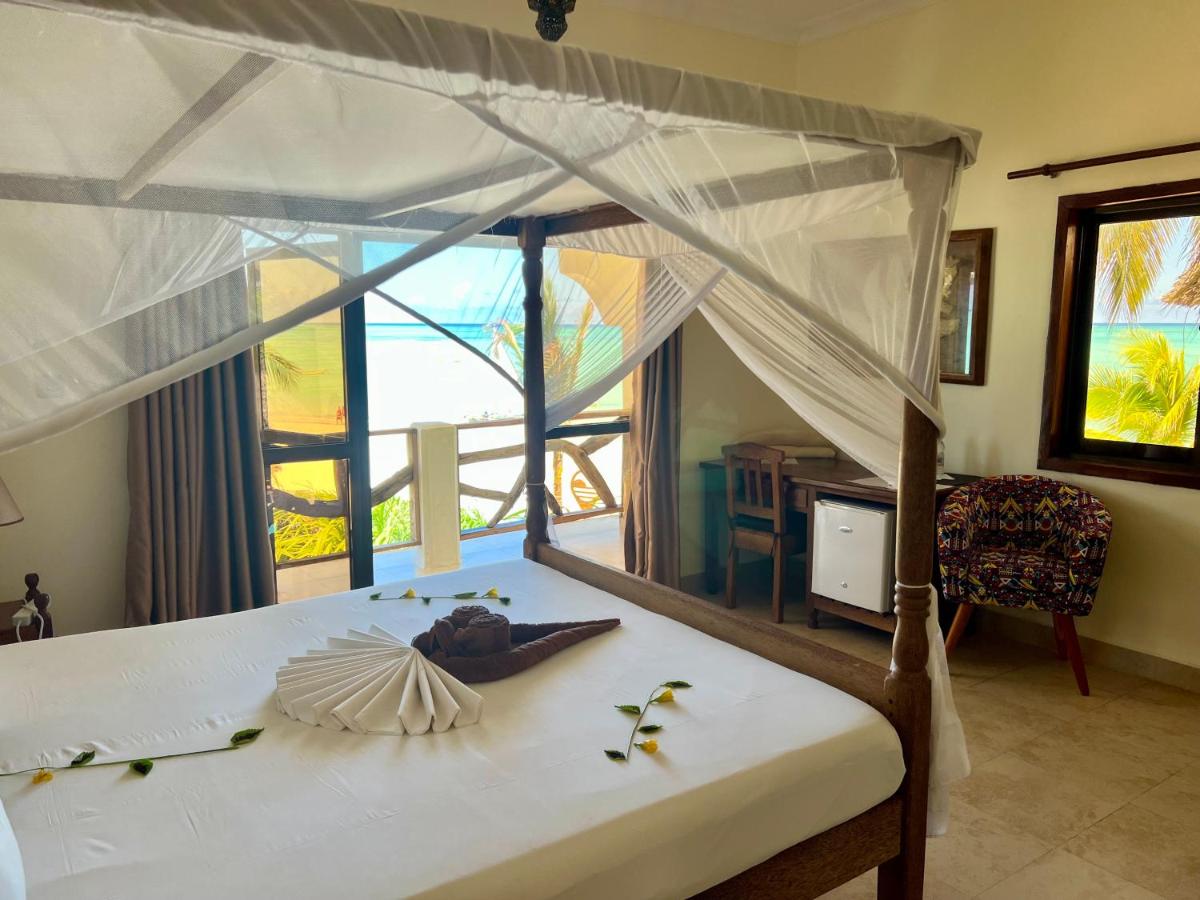 Double room with mosquito netting and an ocean-facing balcony at Mahali Zanzibar